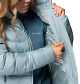 Chaqueta acolchada de mujer con tecnología termorreflectante, cierre frontal completo, cuello alto con protección de barbilla y bolsillos laterales con cremallera. Diseño ligero y resistente a la humedad.