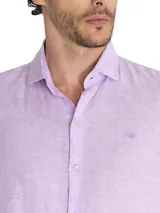 Camisa de manga larga para hombre, confeccionada en lino orgánico color lavanda. Presenta un diseño liso con cuello clásico, cierre frontal con botones y logo bordado al tono en el pecho.