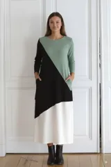 Vestido largo de morley fino, con corte asimétrico en bloques de color verde, negro y blanco, de mangas largas y calce amplio.