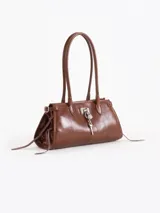 Cartera Kate de cuero vacuno diseñada para llevar al hombro, con cierre principal y bolsillo interno. Presenta aplique de candado y llavero tipo birkin en el frente, además de tiras laterales decorativas.