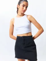 Minifalda de jean negra con corte asimétrico en el frente y deflecado tanto en la cintura como en el ruedo.