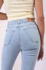 Pantalón de denim celeste claro, de tiro alto y silueta ajustada en caderas y muslos con bota acampanada.