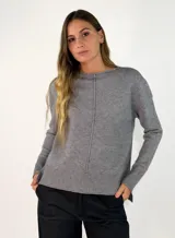 Sweater de punto gris con cuello redondo, manga larga y detalle de costura vertical central. Presenta puños y ruedo acanalados, con un diseño de corte ligeramente más largo en la parte posterior.