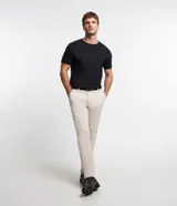 Pantalón de sastrería slim color beige, con bolsillos laterales y cierre frontal con botón y cremallera.