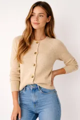 Cardigan de acrílico color beige, de punto liso, con cuello redondo y botones frontales.