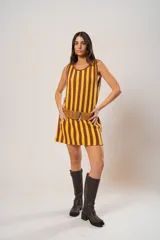Vestido corto tejido a rayas verticales color amarillo y marrón, con escote redondo y mangas sisa. Incluye cinturón marrón con hebilla dorada.