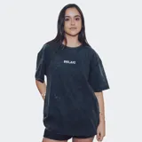 Remera de corte oversize, color negro con efecto acid wash, cuello redondo y manga corta. Presenta un pequeño texto bordado en el pecho que dice "RELAJO".