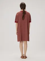 Vestido corto de algodón con estampa geométrica en tonos verde y amarillo, cuello redondo y mangas cortas con puños en color contrastante.