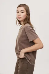 Remera de manga corta y cuello redondo color gris con efecto lavado, calce relajado y detalles de strass aplicados en la parte superior.