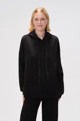 Canguro negro holgado con capucha y cordones ajustables, mangas largas y bolsillos laterales.