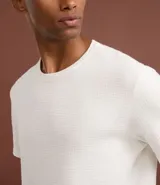 Remera de manga corta con cuello redondo, confeccionada en tejido tipo waffle con textura nido de abeja. Presenta un diseño liso y estructurado, ideal para un look casual y versátil.