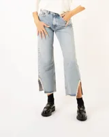 Pantalón de jean celeste de corte recto con roturas en las rodillas y terminación desflecada en el ruedo.