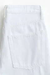Jean de tiro alto con corte wide leg y diseño de cinco bolsillos, confeccionado en denim de algodón rígido.