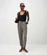 Pantalón femenino de crepé con estampado geométrico en tonos grises y marrones, bajo afunilado, cintura elástica con lazo y bolsillos laterales.