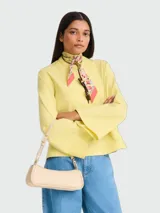 Cartera de hombro pequeña de diseño minimalista y estructura alargada, con correa ajustable y cierre superior.