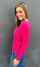 Sweater de punto acanalado color fucsia, con escote en V y mangas largas con puños lisos. Diseño entallado y tejido suave.
