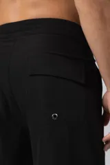 Short de baño color verde oliva, de corte recto y largo hasta la rodilla, con cordón de ajuste blanco en la cintura y bolsillo lateral con etiqueta con logo VCP.