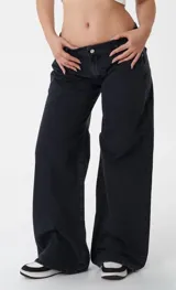 Pantalón de jean estilo wide leg, de tiro bajo y corte holgado, en color negro lavado.