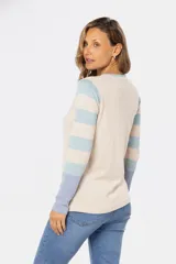 Buzo de tejido fino confeccionado en algodón, con diseño de bloques de color y rayas. Presenta un bloque azul claro en el hombro izquierdo, un bloque beige en el centro y rayas horizontales beige y azul claro en el hombro y brazo derechos. La manga izquierda es de color lila.