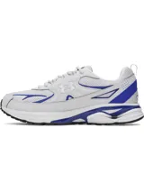 Championes Under Armour modelo Apparition Tech, diseño retro inspirado en el running con base blanca y detalles en azul vibrante. Presenta una parte superior de malla transpirable con superposiciones de cuero sintético, amortiguación reactiva UA HOVR y suela de goma completa.