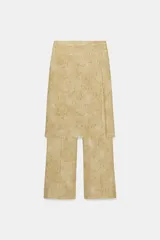 Pantalón de tiro medio con diseño de pierna recta y detalle de superposición tipo pareo en el frente con botones. Cuenta con cierre de cremallera oculto.