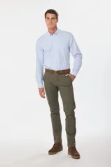 Pantalón de gabardina color marrón claro, corte slim fit, con bolsillos laterales y traseros. Se ajusta a la cintura con cinturón de cuero marrón.