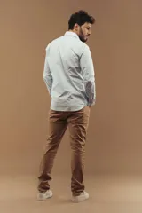 Camisa de vestir de manga larga en color blanco, con cuello clásico y cierre frontal de botones.