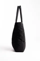 Bolso plateado acolchado con logo ovalado negro y blanco.