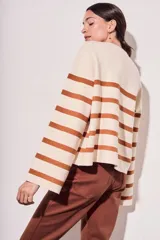 Sweater de punto con diseño a rayas horizontales en color crema y marrón, de corte holgado, cuello redondo y mangas largas acampanadas.