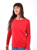 Remera blanca de manga larga con cuello redondo y detalle de botones dorados en los hombros.