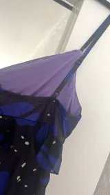 Vestido corto con estampado de mariposas azules y negras, escote en V con volantes y tirantes finos.