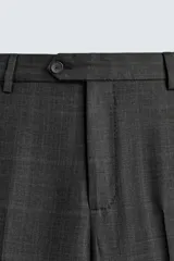 Pantalón de traje de corte regular fit confeccionado en lana de origen italiano. Presenta un diseño de cuadros sutiles, bolsillos laterales, bolsillos traseros de doble vivo con botón y cierre frontal con cremallera y botón.