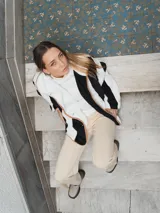 Campera con capucha, de tela tipo peluche a rayas verticales color marrón y blanco, con ribete color beige.