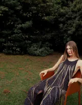 Vestido midi de crochet con hilos de lurex, diseño sin mangas con escote redondo y detalle de flecos largos en el frente.