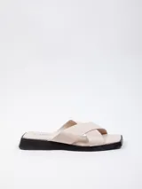 Sandalia baja color beige con dos tiras finas cruzadas de símil cuero.