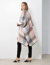 Ruana de tejido soft, marca Barrington, con diseño a cuadros grandes en tonos mostaza, gris oscuro y blanco. Presenta terminación en zig zag con lana en los bordes.