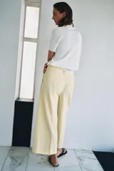 Pantalón cropped de tiro medio color blanco, perteneciente a la colección ZW Collection, con cintura con trabillas, bolsillos laterales ocultos, pinzas en el delantero, pierna ancha y cierre frontal con cremallera, botón y ganchos metálicos.