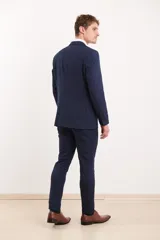 Ambo de corte entallado en color azul oscuro, compuesto por saco de dos botones con solapa clásica y pantalón de vestir a juego.