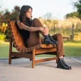 Bota corta de cuero vacuno color negro, con diseño de punta cuadrada y suela de goma tipo track. Presenta doble cierre metálico lateral y una estética robusta y moderna.