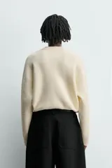Jersey de punto con textura efecto pelo, corte relajado, cuello redondo y manga larga con acabados en rib.