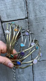 Gargantilla artesanal con cuatro hilos de bronce y alpaca, adornada con piedras de diferentes colores y formas.