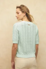 Top tramado color crudo, de manga corta, cuello redondo y elástico en la cintura y mangas.