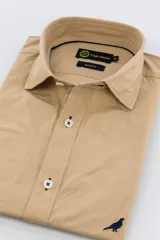 Camisa color beige de algodón poplin lavado, corte slim fit, manga larga, cuello clásico y cierre con botones.