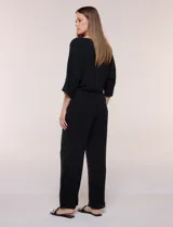 Pantalón pull-on de color beige con caída fluida, cintura elastizada fruncida, bolsillos laterales funcionales y pierna amplia de corte wide leg.