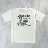 Remera color natural de algodón con estampa en la espalda de una cobra, un cuenco y la frase "strike first strike hard no mercy" de la marca Duxon Jeans.
