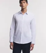 Camisa de vestir blanca de algodón con textura maquinetada, cuello camisero y mangas largas.