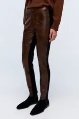 Pantalón calza marrón con frente de cuero sintético y parte trasera de tela elástica negra.