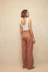 Pantalón de pana azul grisáceo, de tiro alto y corte acampanado, con cinturón incorporado y bolsillos laterales.