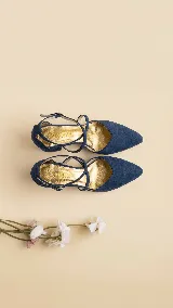 Zapato de tacón ancho de 5 cm, confeccionado en tela de tapicería resistente color negro. Presenta un diseño con escote en V y tiras cruzadas en diagonal con cierre de hebilla en el tobillo. Cuenta con forro y plantilla de cuero.