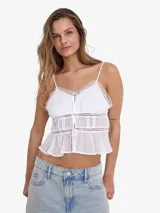 Blusa blanca sin mangas con tirantes finos, escote en V y volados con detalles de encaje.